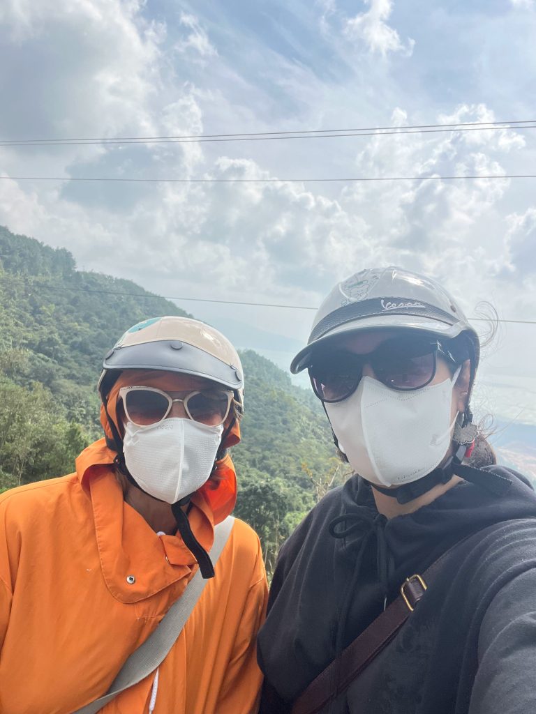 2 women in helmets overlooking a hill vietnam